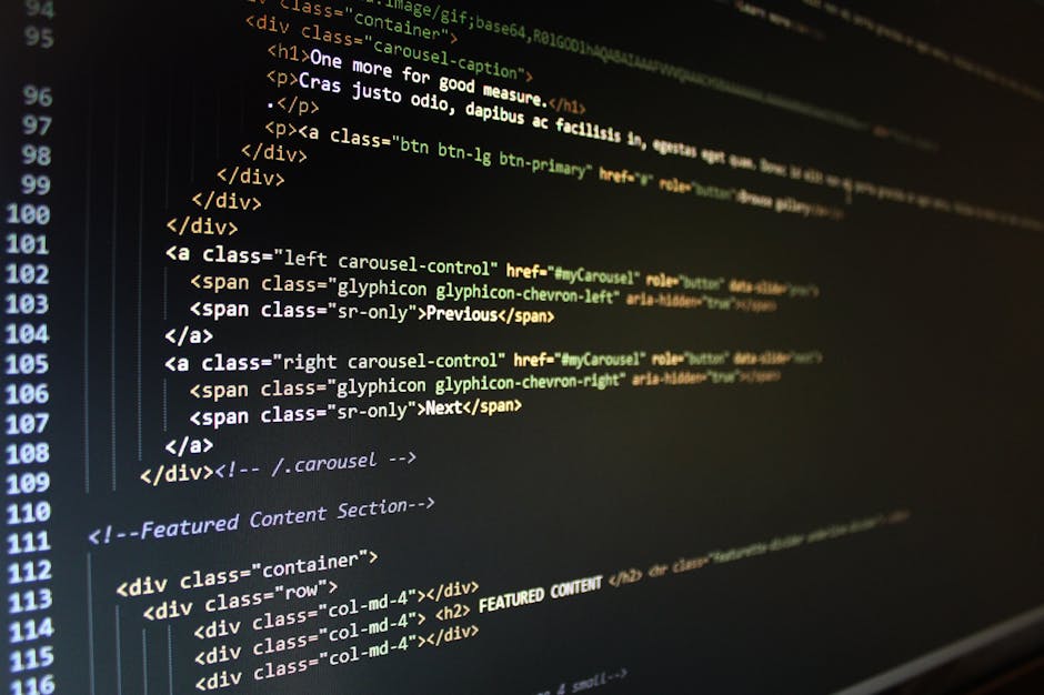 Close-up image of a computer screen displaying lines of HTML code with colorful syntax highlighting, including tags, attributes, and comments. The background shows a dark theme with text in shades of 
